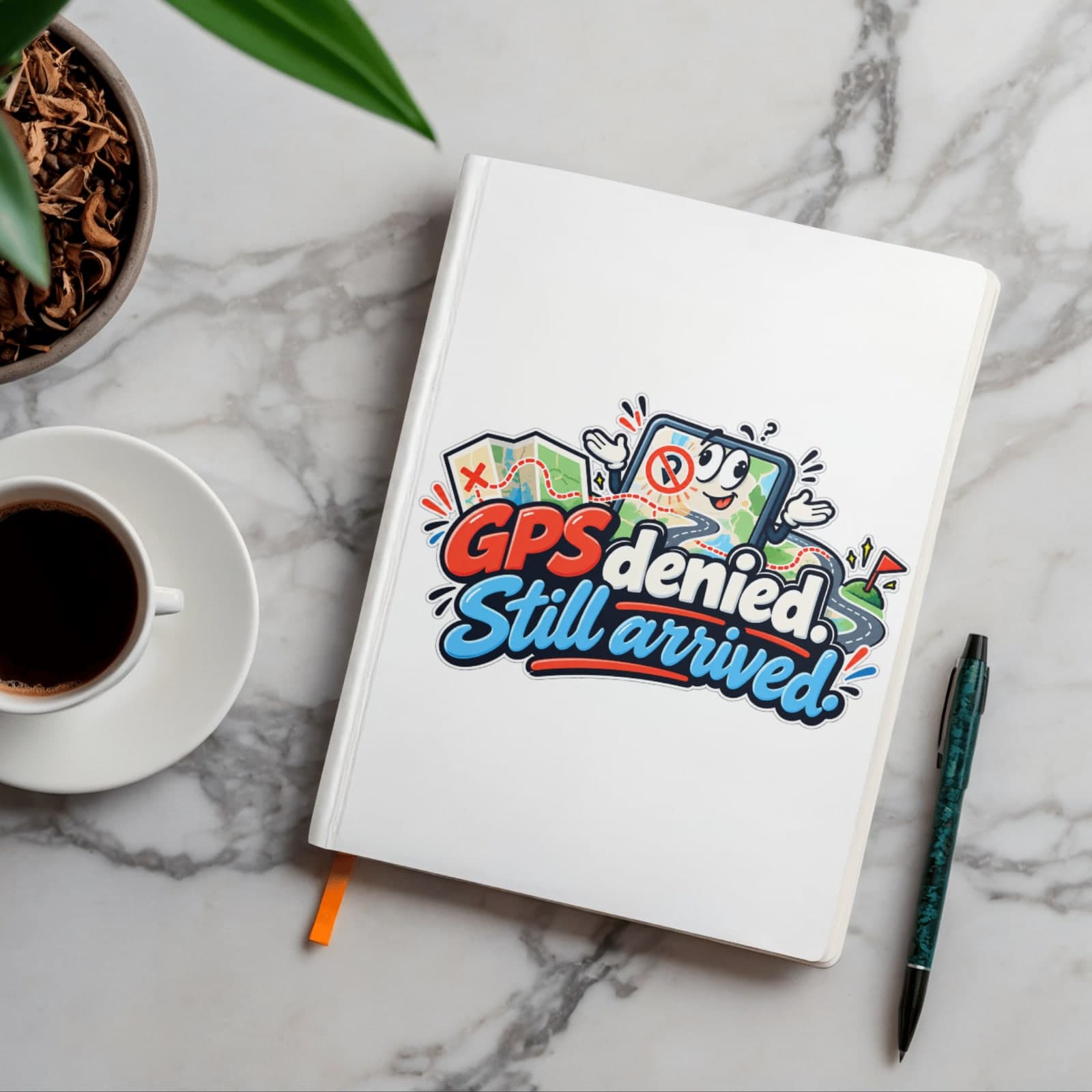 White notebook on a marble desk, printed with a cheerful phone holding a crossed-out location pin and the words GPS denied. Still arrived.